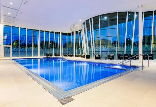 特伦特河畔伯顿圣乔治公园希尔顿酒店的一座大型游泳池,位于一座带窗户的建筑内
