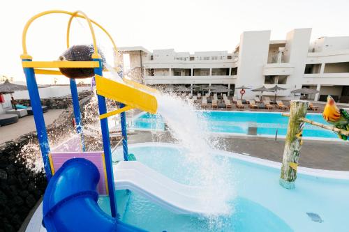 科斯塔特吉塞HD海滩度假酒店的儿童在游泳池的水滑梯玩耍