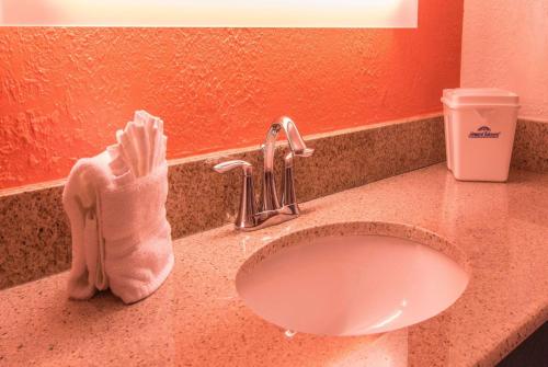 朴茨茅斯朴茨茅斯霍华德约翰逊酒店的浴室柜台配有水槽和毛巾