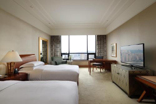重庆重庆希尔顿酒店的酒店客房设有两张床和大窗户。