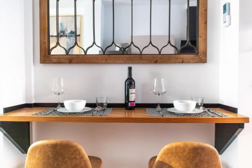 塞维利亚Calma Suites的一张桌子、两把椅子和一瓶葡萄酒