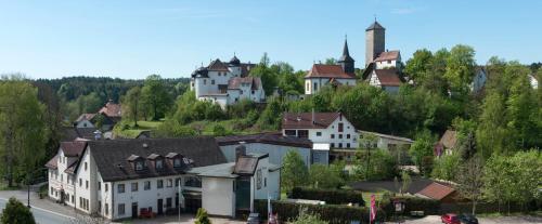 奥夫塞斯Brauereigasthof Rothenbach的山丘上的村庄,有房子和教堂
