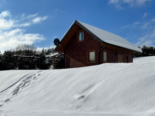 巴利格鲁德Domek na Słonecznym Pagórku的雪中的房子,前面有脚印