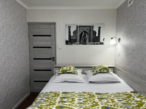 费尔干纳Status House的一间卧室配有带2个枕头的床