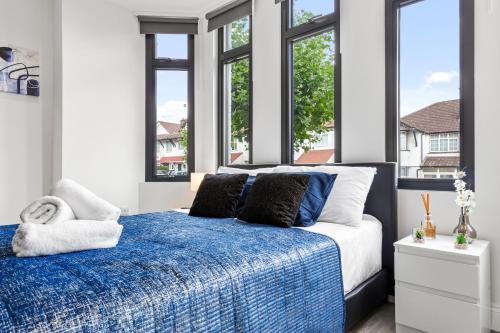The HydeComfy 1BDR - 30mins to CENTRAL LDN - Parking的卧室设有蓝色和白色的床和窗户。