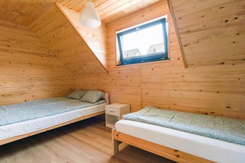 詹塔尔Osada Jantar 3的小木屋内一间卧室,配有两张床