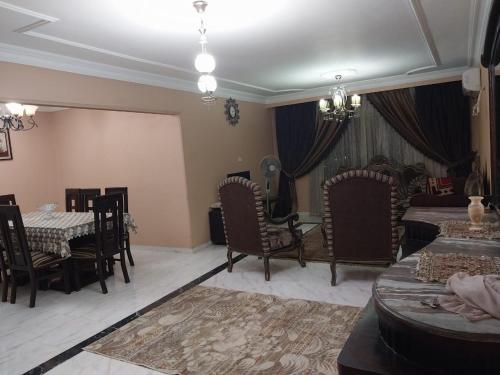 开罗Compound city towers的客厅配有椅子、桌子和床