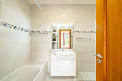 普拉泽里什Vila Sol的白色的浴室设有浴缸和水槽。