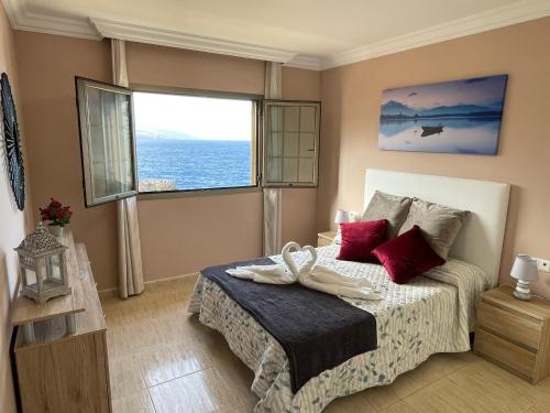 波里斯-德阿沃纳Apartamento Dulce Vista的一间卧室配有一张带红色枕头的床和一扇窗户