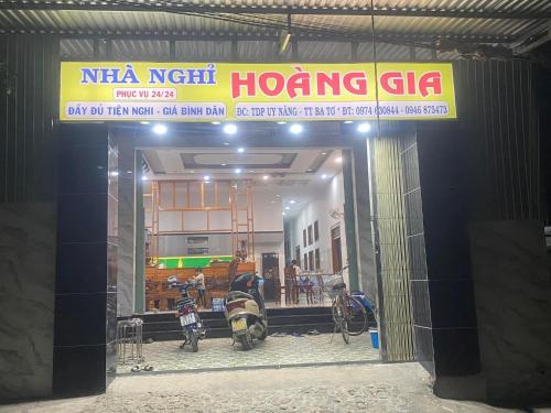 Ba TơNhà nghỉ Hoàng Gia的建筑物前方有标志的商店