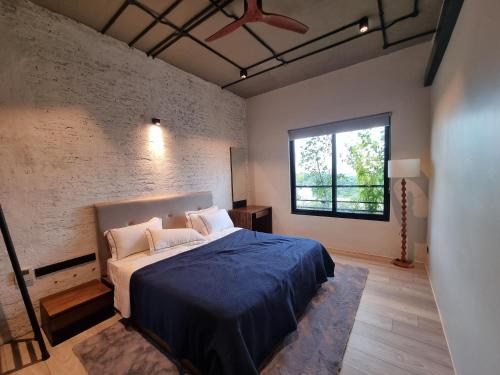 科伦坡VAUX PARK STREET Extended Stay Suites & Apartments in Central Colombo的一间卧室配有一张带蓝色毯子的床和窗户。