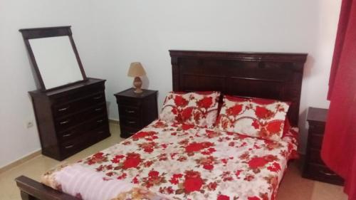 萨菲الحي المحمدي آسفي的一间卧室配有一张带红白毯子的床