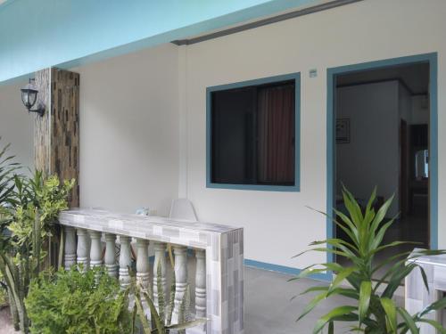 马拉帕斯加ELEN INN - Malapascua Island FAN ROOM #1的白色的房子,带有阳台,电视