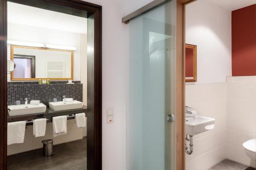 特里尔佑蕾娜霍夫酒店的浴室设有2个水槽和镜子