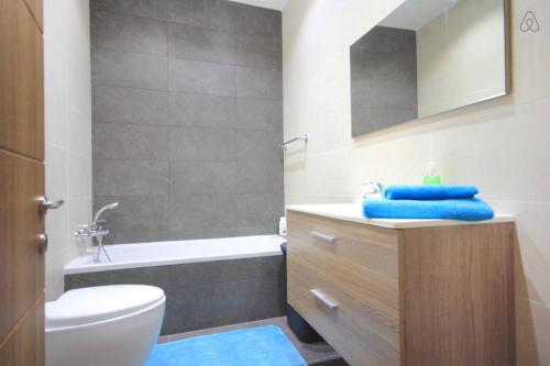 MġarrÉtoile Court Apt - homey, spacious & private patio的浴室配有盥洗盆、卫生间和浴缸。