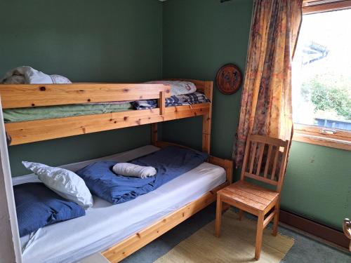 布莱尼Stemmen 16的一间卧室配有两张双层床和椅子