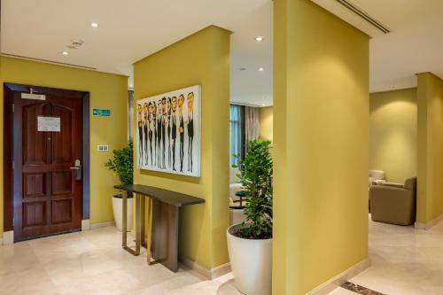 利雅德格拉纳达维维恩别墅酒店的大堂设有黄色的墙壁和桌椅