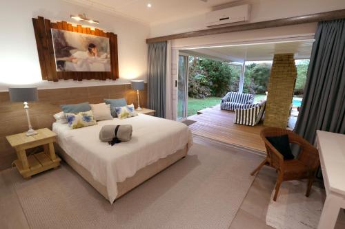 谢普斯敦港Fiddlewood Beach House的一间带大床的卧室和一个露台