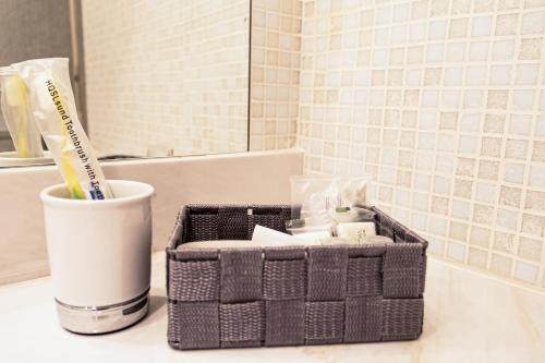 罗马Charme & Chic San Giacomo的浴室柜台配有洗浴用品篮和牙刷