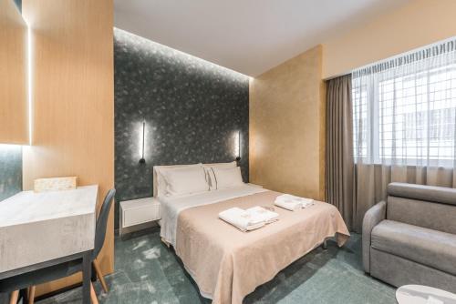 地拉那Piazza Luxury Apartments的配有一张床和一把椅子的酒店客房