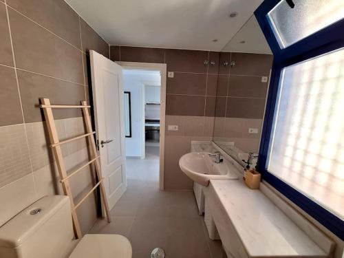莫哈卡尔Sea view cozy apartment La Tanita的一间带水槽和卫生间的浴室以及窗户。