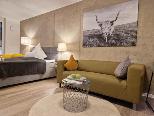 比勒费尔德Urban City Lifestyle Appartement的客厅配有沙发和墙上的牛