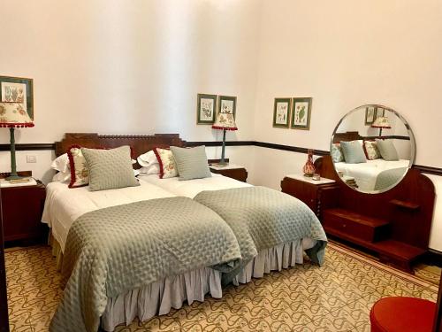 大加那利岛拉斯帕尔马斯Casa Colonial El Indiano的酒店客房,设有两张床和镜子