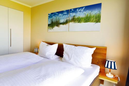 库克斯港Haus Horizont H511的配有白色枕头的酒店客房内的两张床