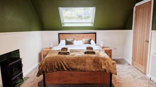 牛顿斯图尔特Nordlys Cottage的一间卧室设有一张带绿色墙壁和窗户的床。