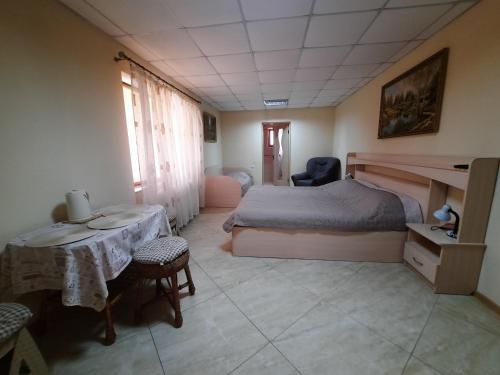喀尔巴阡КОМФОРТ的卧室配有一张床和一张桌子及椅子