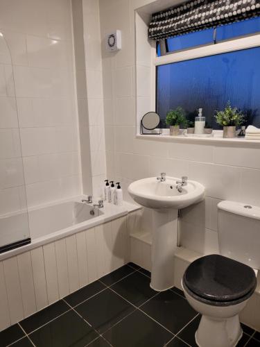 达宁顿堡4 Bedroom House EMA with Parking and Garage的浴室配有盥洗盆、卫生间和浴缸。