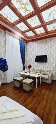 Andizhansheykh hotel的客房拥有格子天花板,配有桌子和沙发