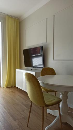 埃尔布隆格Apartament na Starówce的一间带桌椅和电视的用餐室
