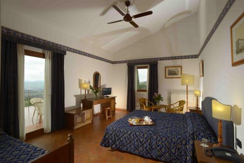 圣多纳托因弗伦萨诺夜莺农场酒店的一间卧室配有一张床和吊扇