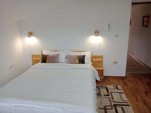 古拉哈莫卢洛伊Casa Popa的卧室配有一张带白色床单和枕头的大床。
