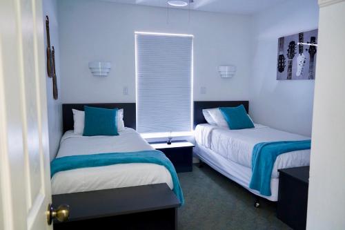 基西米Enchanting Escape 3 Bedroom Minutes from Disney!的蓝色和白色的客房内的两张床