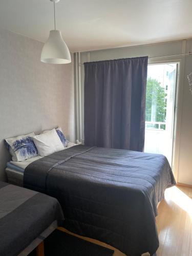 图尔库City apartment Pikkuvuori的一间卧室配有一张带蓝色毯子的床和窗户。