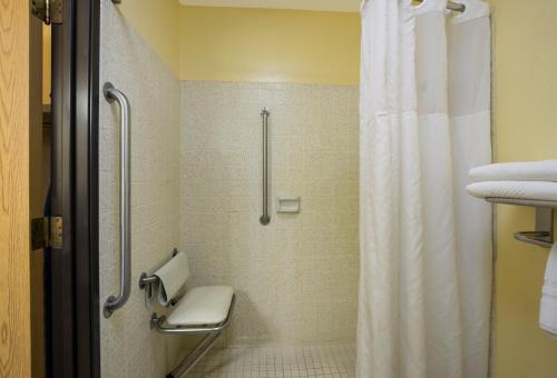 梅德福梅德福机场品质套房酒店的带淋浴、卫生间和浴帘的浴室