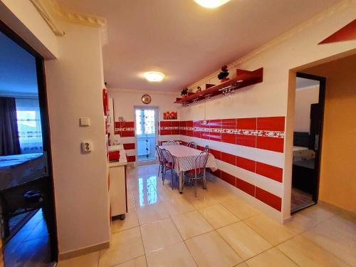 科瓦斯纳Apartman Lux的墙上有红色和白色条纹的用餐室