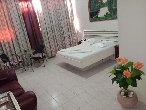 巴西利亚Hotel Canal Hum的卧室配有一张床和一张桌子及椅子