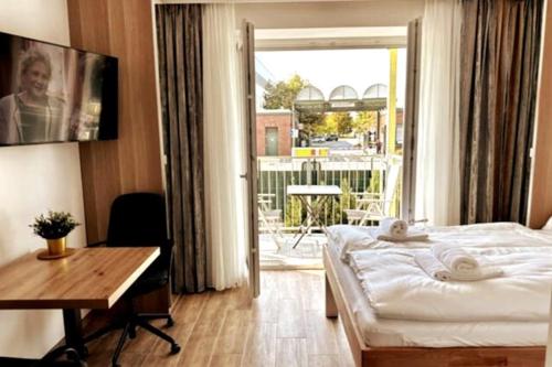 维也纳AJO Vetmed的一间卧室配有一张床、一张书桌和一个窗户。