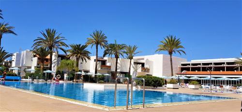 德尔锡伦西奥海岸Ke Casetta Tenerife的一座棕榈树和建筑的大型游泳池