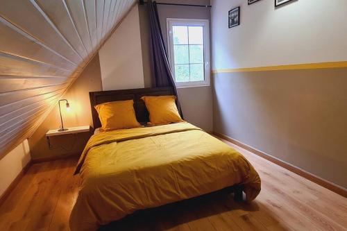 圣若瑟L'escapade sauvage的一间卧室配有一张带黄色床单的床和一扇窗户。