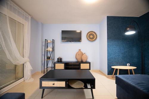 佩雷亚Maisonette PT的客厅配有桌子和墙上的电视