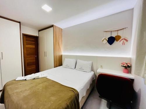 维拉维尔哈Praia Dourada的一间小卧室,配有一张床和一把椅子