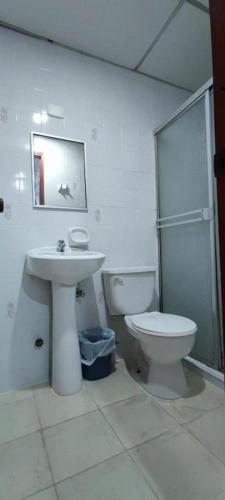 巴拿马城Hostal Cigarra的白色的浴室设有卫生间和水槽。