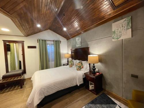 蒙泰韦尔德哥斯达黎加Camino Verde B&B Monteverde Costa Rica的卧室设有白色的床和木制天花板。