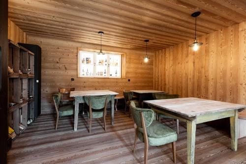 阿尔迪诺Michlhaus nature and suites的用餐室设有木墙和桌椅