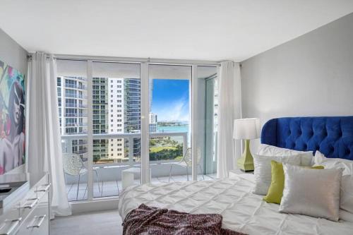 迈阿密Unforgettable! Water & Park Views, 4 Bedrooms!的一间卧室设有蓝色的床和大窗户
