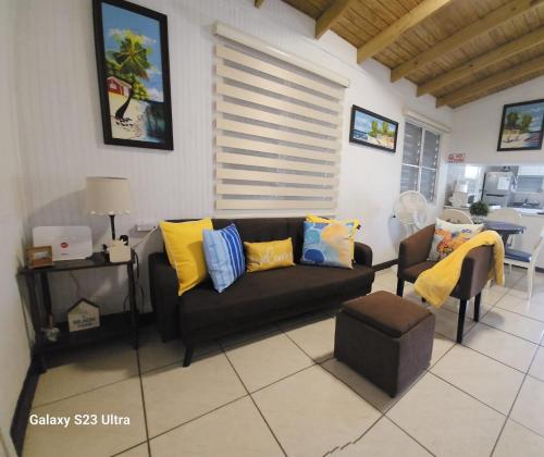 Casita Playera Aguadeña的客厅配有黑色沙发和黄色枕头